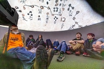 Ethan Austin, STEM outreach volunteer, watches a video with middle school students inside an inflatable planetarium, April 19, 2025, during “Navy STEM Days” at the U.S. Undersea Museum at Naval Undersea Warfare Center, Keyport, Washington. (U.S. Navy photo by Jeb Fach)