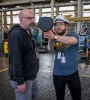 Jack Housley, project lead, Code 100TO.3, Innovation and Technology Integration, shows Harrison Belyea, plates bay manager, Shop 11, Shipfitters, how leak detectors work, April 3, 2025, at Puget Sound Naval Shipyard & Intermediate Maintenance Facility in Bremerton, Washington. (U.S. Navy photo by Wendy Hallmark)