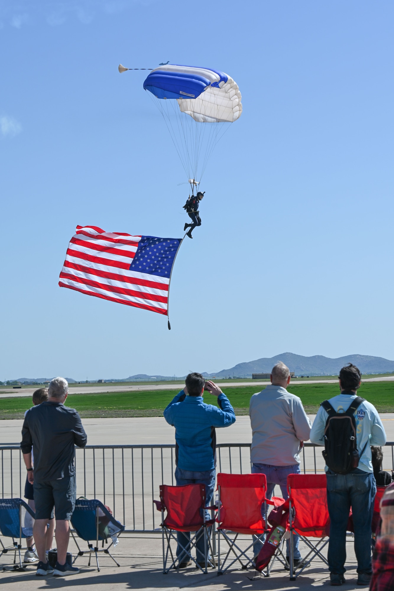 A instructor from the United States Air Force Academy Wings of Blue Parachute Team prepares to land at the Altus Airpower Stampede Open House and Air Show at Altus Air Force Base, Oklahoma, April 12, 2025. The jump was part of several parachute jumps performed for the Altus Airpower Stampede Open House and Air Show. (U.S. Air Force photo by Airman 1st Class Jonah Bliss)