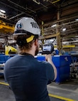 Jack Housley, project lead, Code 100TO.3, Innovation and Technology Integration, demonstrates how to use an ultrasonic leak imaging tool April 3, 2025, inside Building 460 at Puget Sound Naval Shipyard & Intermediate Maintenance Facility in Bremerton, Washington. (U.S. Navy photo by Wendy Hallmark)