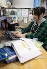 Alexandra Kopecky, refrigerator technician, Shop 06, Tooling and Maintenance, does homework for school during her lunch break, April 3, 2025, at Puget Sound Naval Shipyard & Intermediate Maintenance Facility in Bremerton, Washington.. Kopecky attends Olympic College through the school's After-Hours Program. (U.S. Navy photo by Wendy Hallmark)