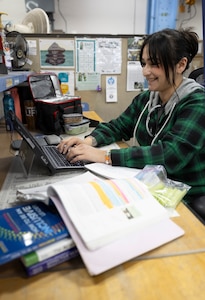 Alexandra Kopecky, refrigerator technician, Shop 06, Tooling and Maintenance, does homework for school during her lunch break, April 3, 2025, at Puget Sound Naval Shipyard & Intermediate Maintenance Facility in Bremerton, Washington.. Kopecky attends Olympic College through the school's After-Hours Program. (U.S. Navy photo by Wendy Hallmark)