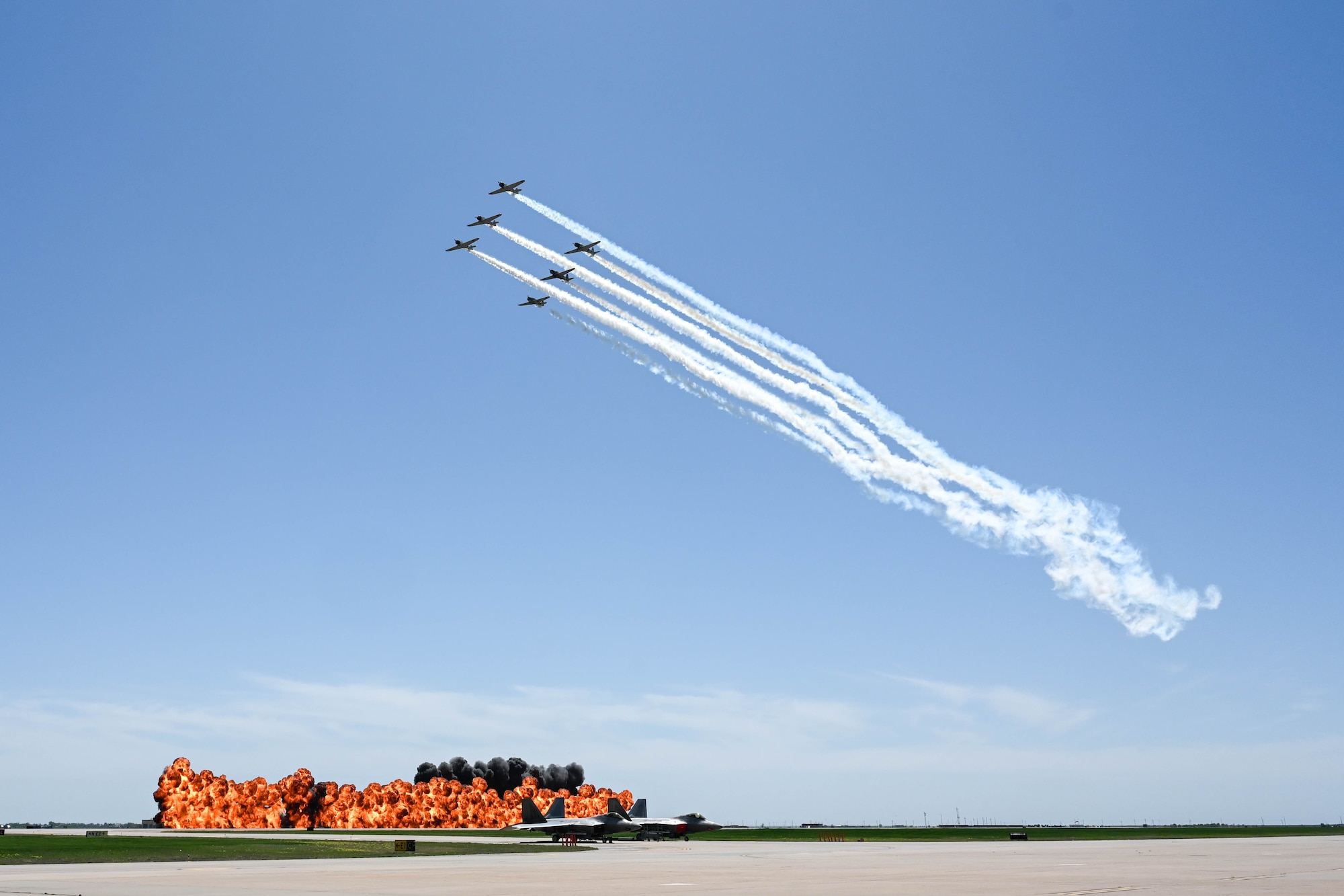 Civilian aircraft performers, Tora! Tora! Tora!, fly in formation above a wall of fire during the Altus Airpower Stampede Open House and Air Show at Altus Air Force Base, Oklahoma, April 13, 2025. Tora! Tora! Tora! delivers a historically detailed account of the events leading to the Japanese attack on Pearl Harbor, portraying both American and Japanese perspectives. (U.S. Air Force photo by Airman 1st Class Lauren Torres)