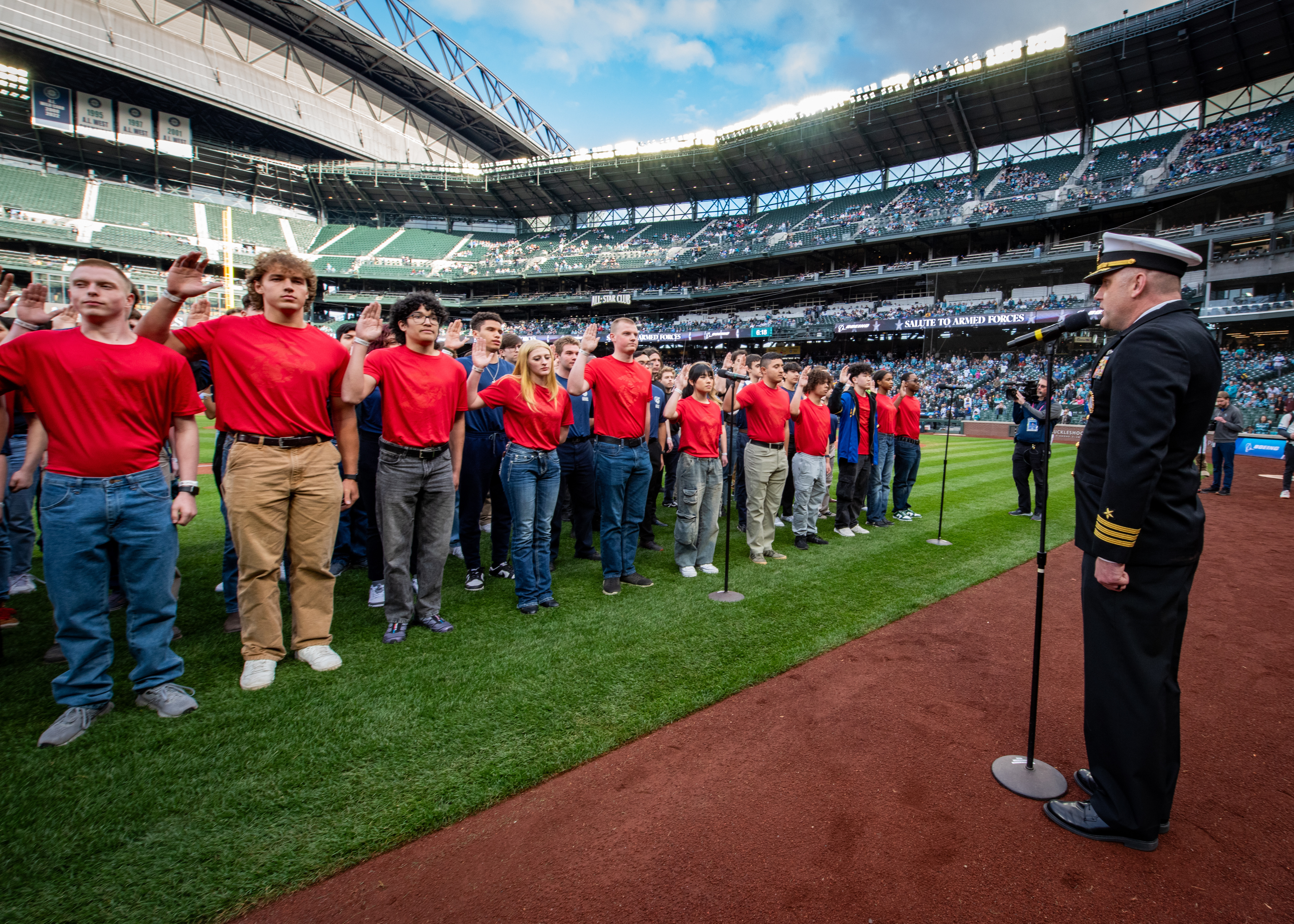 U.S. Navy Cmdr. Richard Jarchow leads future service members in the oath of enlistment during a joint-service ceremony at T-Mobile Park, part of Seattle Mariners’ Salute to Armed Forces Night.