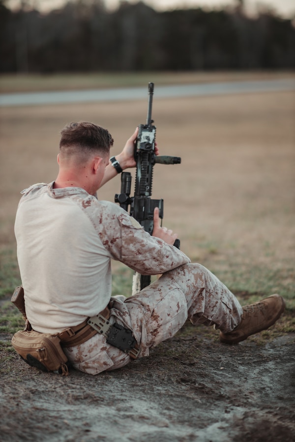U.S. Marine Corps Cpl. Lars Hoffberg, a network administrator, 2nd Light Armored Reconnaissance Battalion, 2nd Marine Division, checks over his M27 Infantry Automatic Rifle during the 2025 Marine Corps Marksmanship Competition-East at Stone Bay on Marine Corps Base Camp Lejeune, North Carolina, March 11, 2025. Marines from east of the Mississippi are invited to the annual competition to enhance their combat effectiveness by employing advanced training tactics during both day and night operations. (U.S. Marine Corps photo by Sgt. Andrew Skiver)