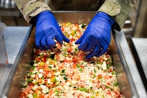An Airman prepares couscous primavera.