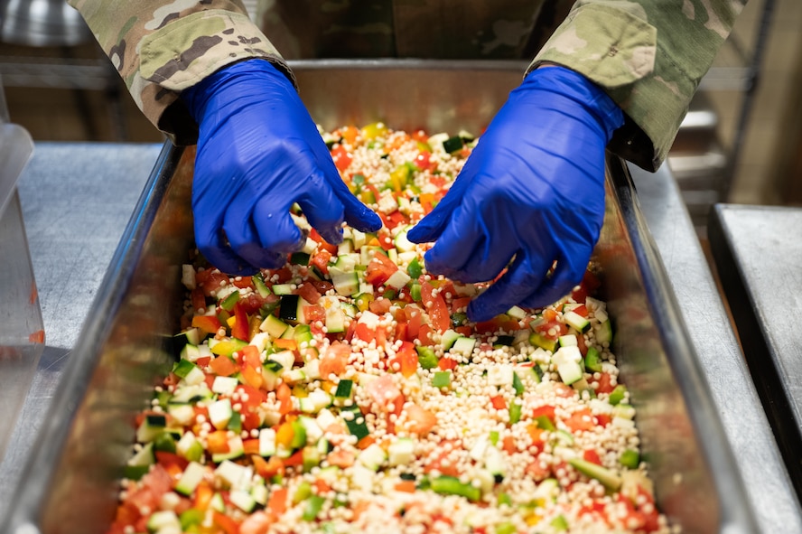 An Airman prepares couscous primavera.