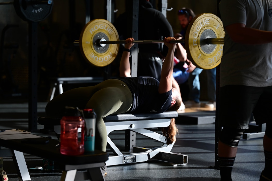 A person lifts a weight in a gym