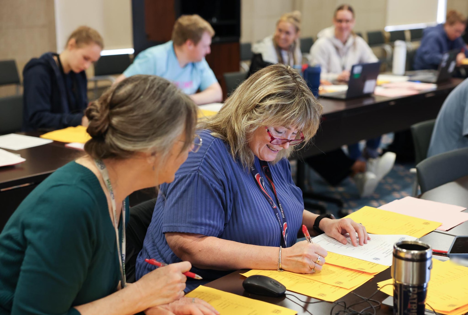 Carderock employees Maureen Foley (right) and Melanie Zajic (left) from the Platform Integrity Department, volunteer to help score students’ written examinations from the individual sprint and team rounds during the Carderock Math Contest (CMC) on April 4, 2025, in West Bethesda, Md.