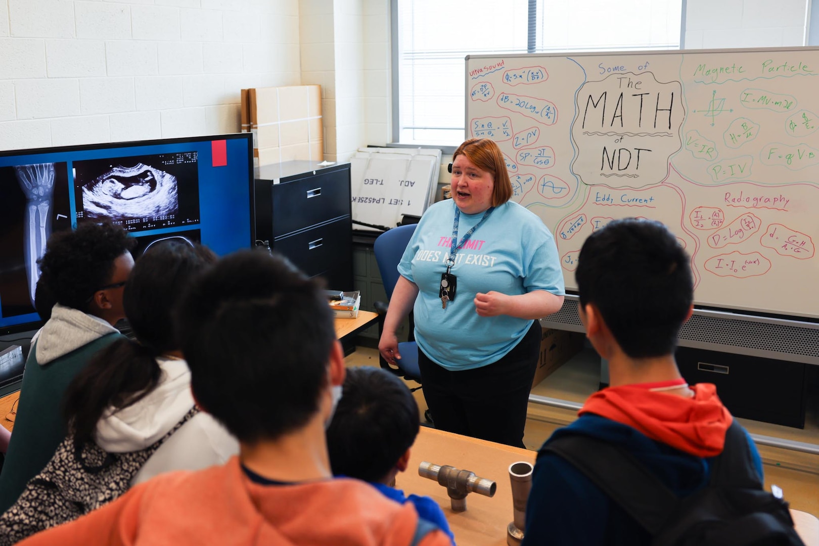 Engineer Margaret Zantow from Naval Surface Warfare Center Carderock Division’s Non-Destructive Evaluation Laboratory engages with students on a tour of the lab during the Carderock Math Contest on Friday, April 4, 2025, in West Bethesda, Maryland.