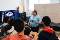 Engineer Margaret Zantow from Naval Surface Warfare Center Carderock Division’s Non-Destructive Evaluation Laboratory engages with students on a tour of the lab during the Carderock Math Contest on Friday, April 4, 2025, in West Bethesda, Maryland.
