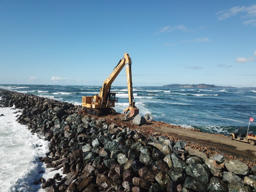 A picture of an excavator on top of the south jetty is pictured.