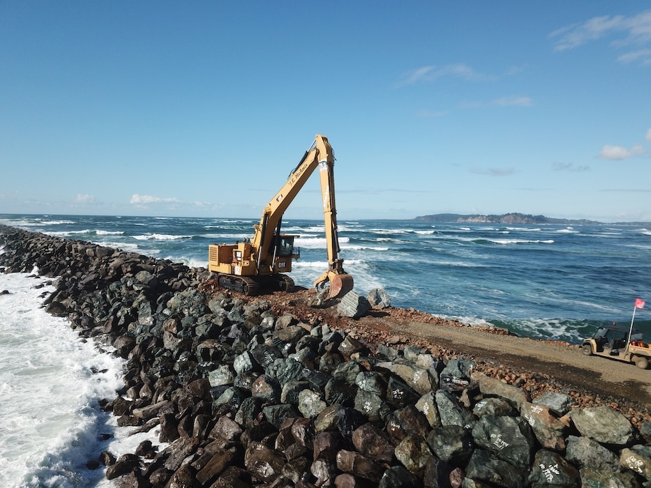 A picture of an excavator on top of the south jetty is pictured.