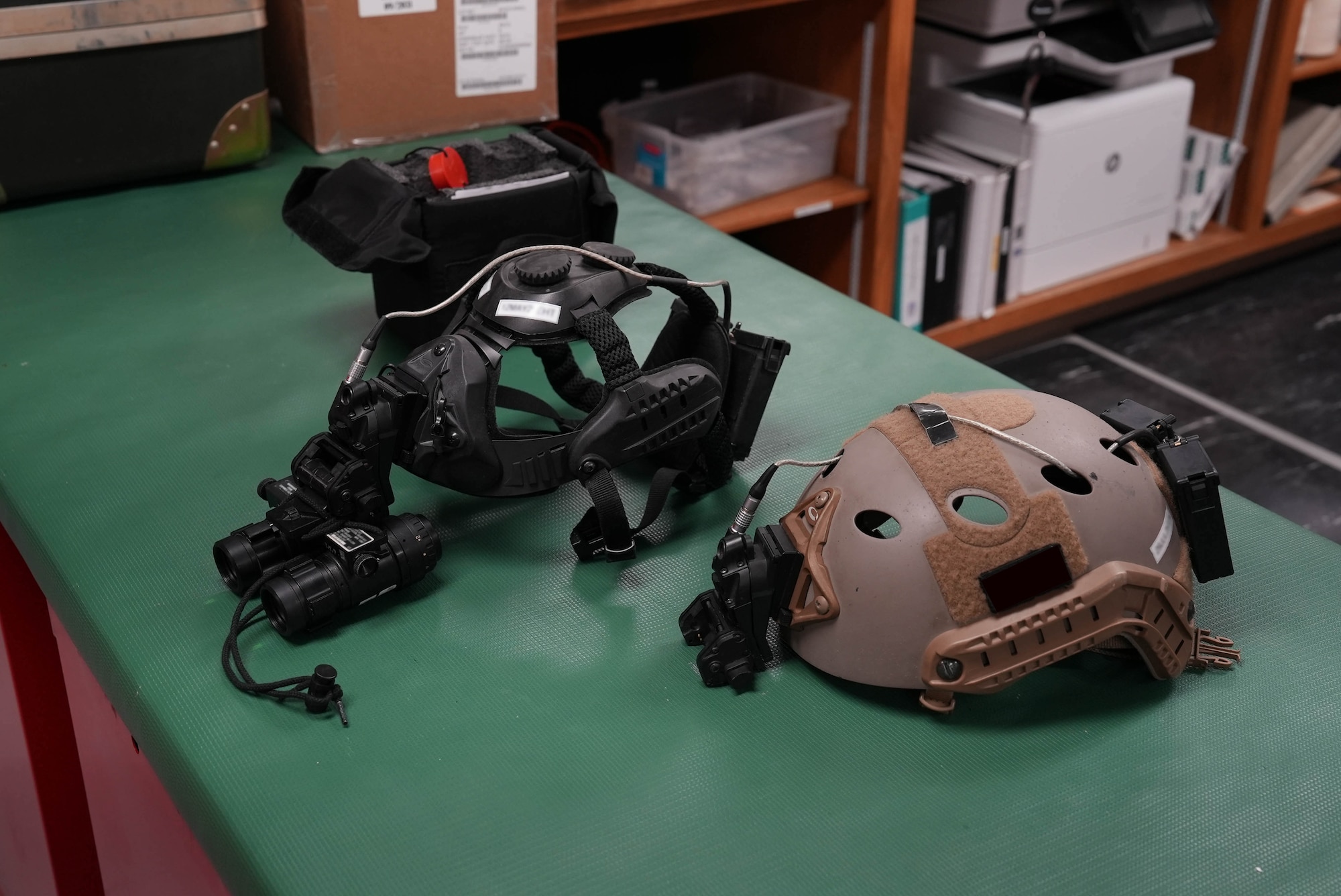 A Skull Mounting System and FAST SF Non-Ballistic Helmet are laid out on a counter in an aircrew flight equipment section at Cannon Air Force Base, New Mexico, March 17, 2025. The Skull Mounting System is designed to align headgear with night vision goggles or other accessories, ensuring crews are ready to operate any place, any time, anywhere. (U.S. Air Force photo by Staff Sgt. Kevin Williams)