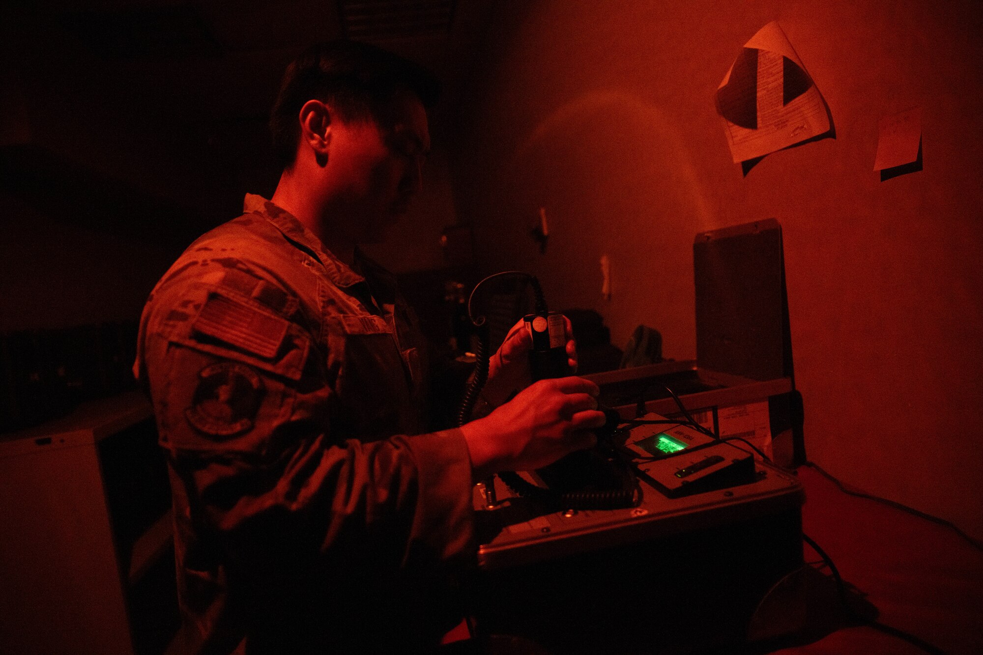 A McConnell airman checks for dust on night vision goggles
