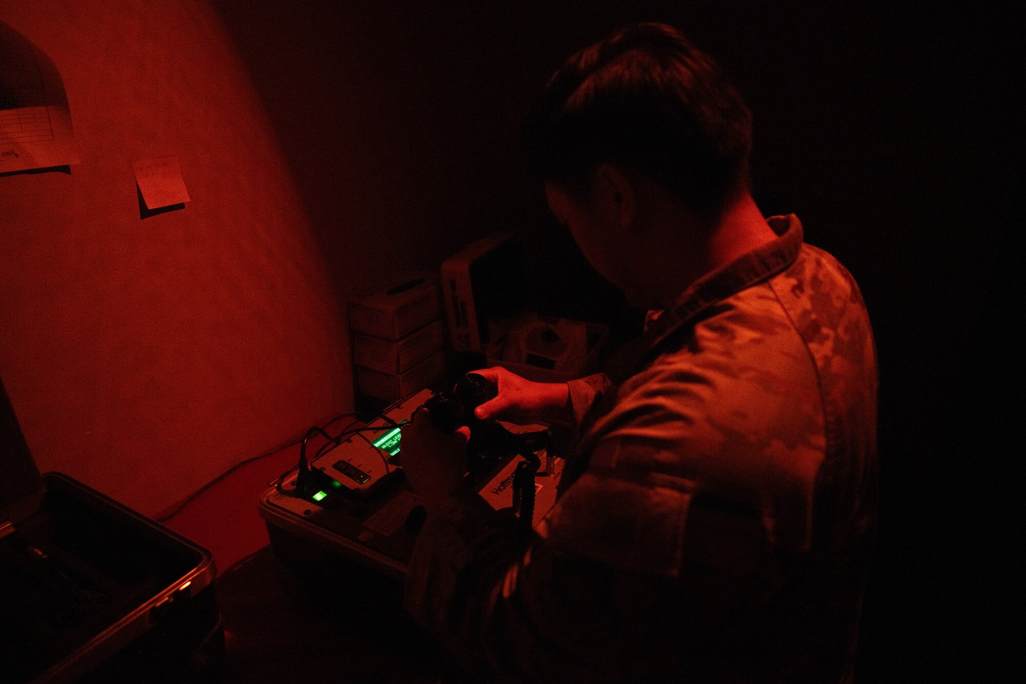 A McConnell Airman mounts night vision goggles to a testing machine