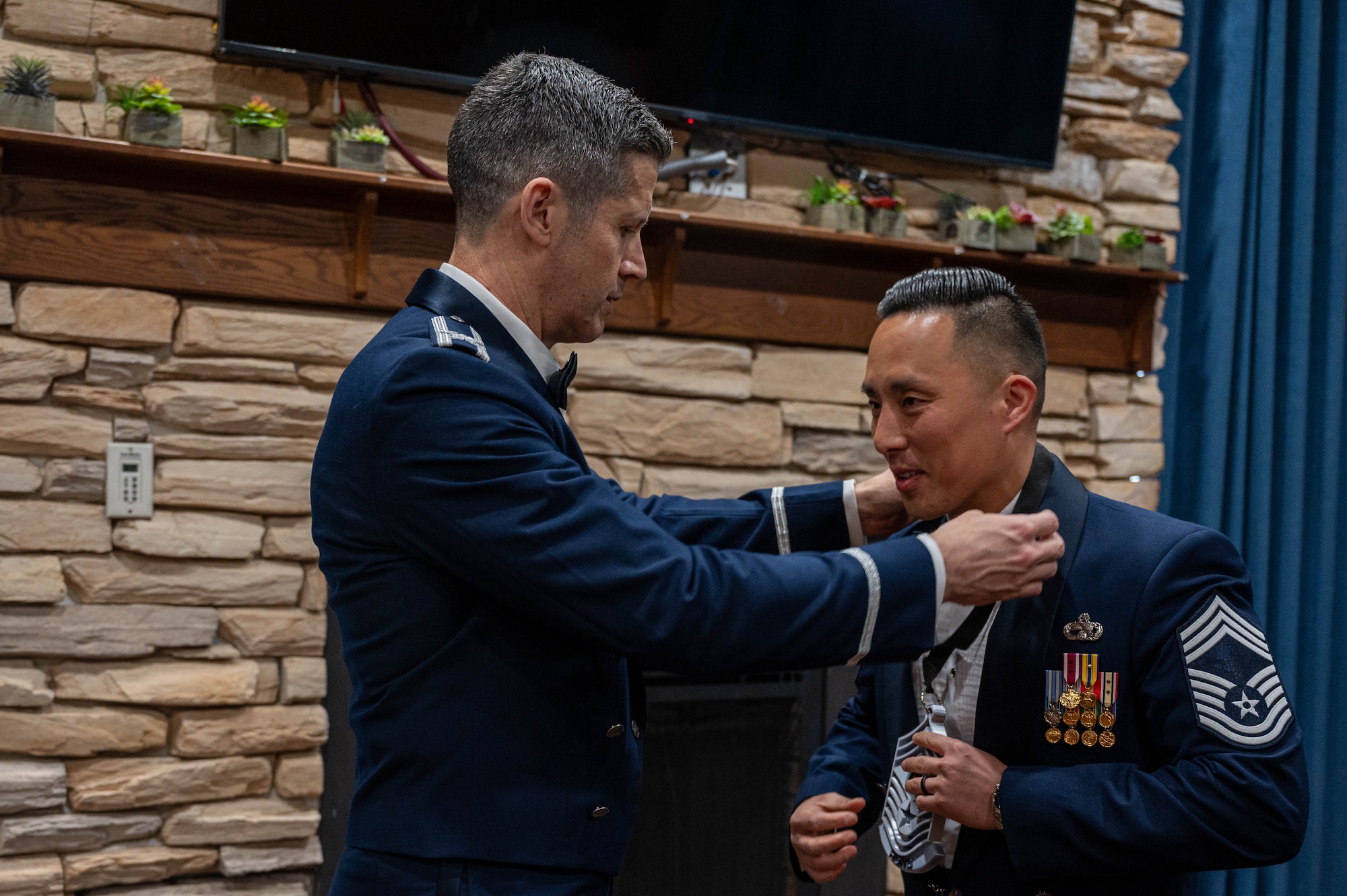 U.S. Air Force Col. William McKibban, 51st Fighter Wing commander, left, places a medallion around Chief Master Sgt. Kevin Hong, 51st Logistics Readiness Squadron deployment and distributions flight chief, during the 2025 Chief Recognition Ceremony at Osan Air Base, Republic of Korea, April 11, 2025. The event recognized Osan’s newly selected chief master sergeants and celebrated their achievements as they progressed in their military careers. (U.S. Air Force photo by Staff Sgt. Christopher Tam)