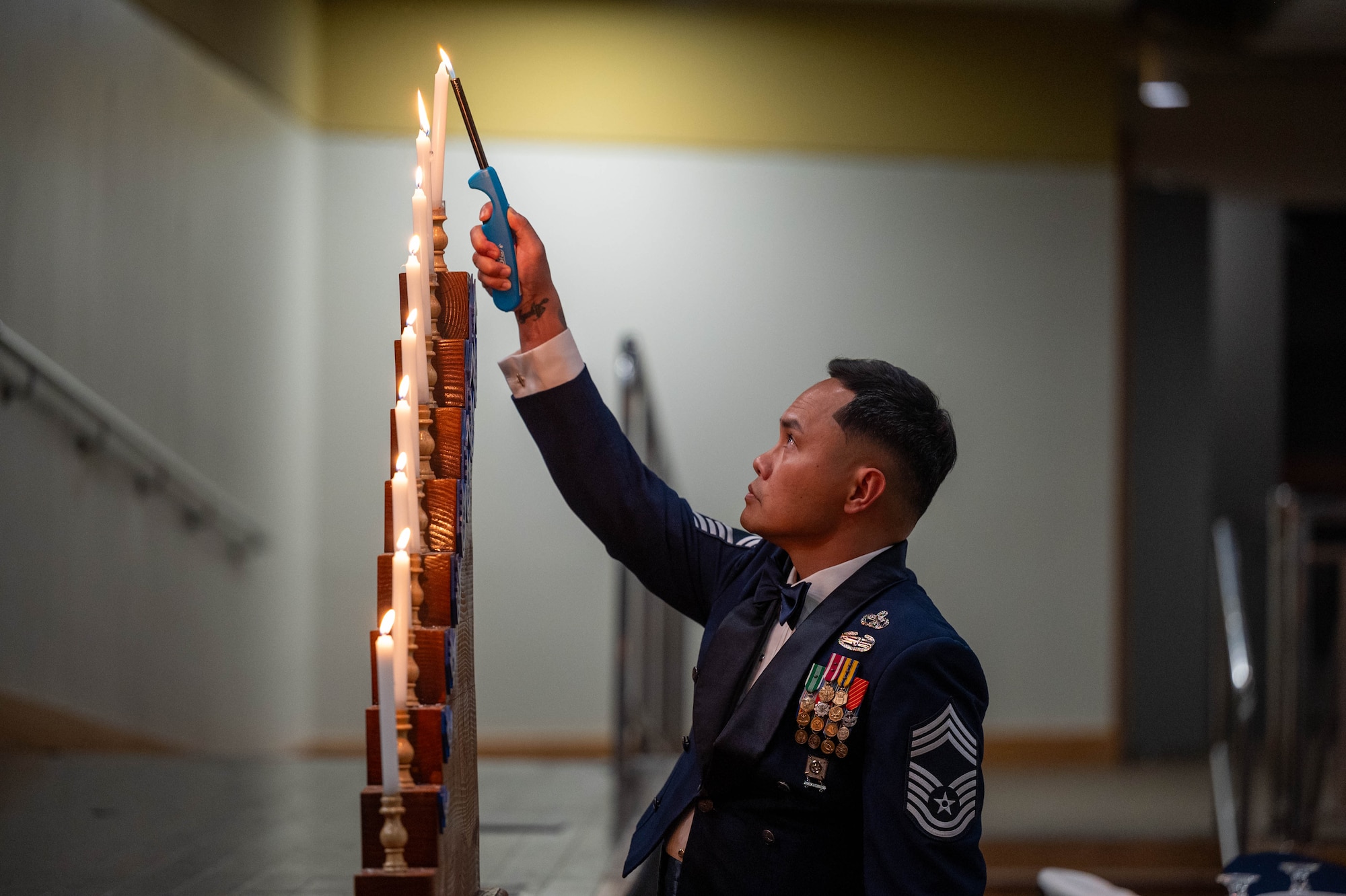 U.S. Air Force Chief Master Sgt. Junyville Gianan, 51st Logistics Readiness Squadron senior enlisted leader, lights a candle during the 2025 Chief Recognition Ceremony at Osan Air Base, Republic of Korea, April 11, 2025. The candle lighting ceremony represents the Air Force ranks from airman basic to chief master sergeant. (U.S. Air Force photo by Staff Sgt. Christopher Tam)