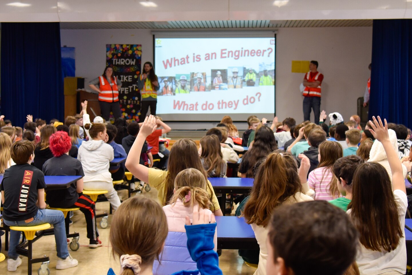 Engineers encourage students during tower building competition.