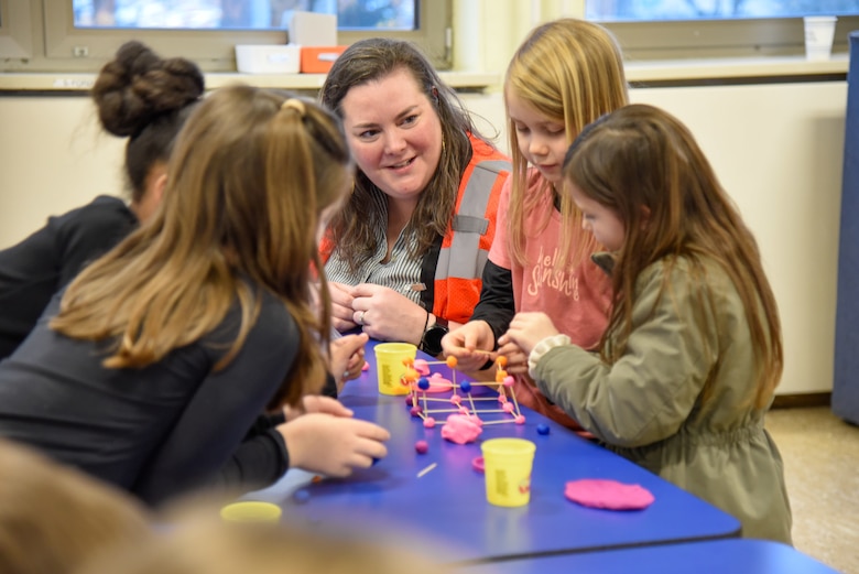 Engineers encourage students during tower building competition.
