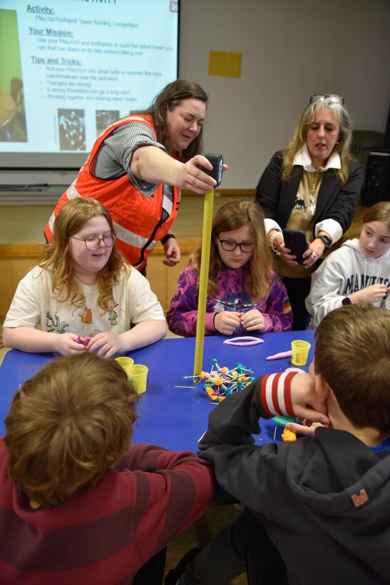 Engineers encourage students during tower building competition.