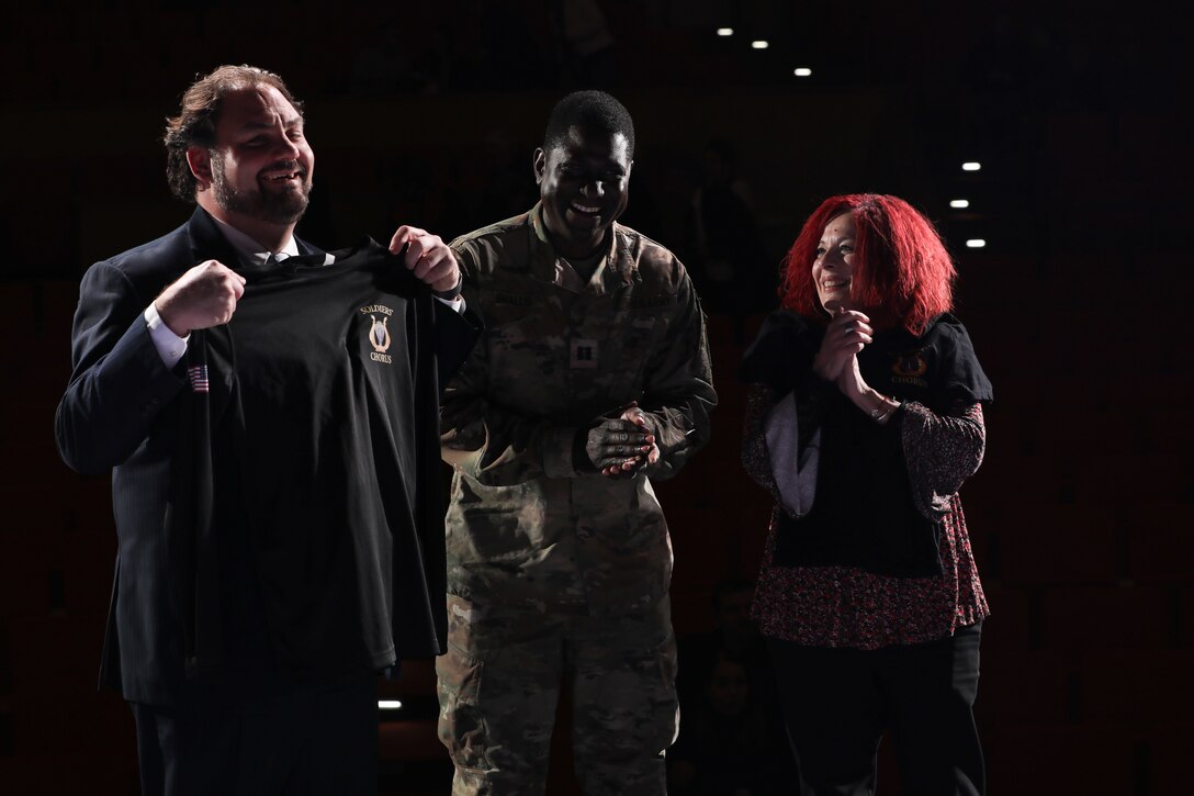 Soldier presenting t-shirts to two of the tour coordinators