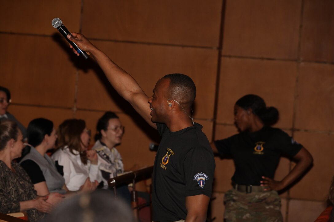 Singer holding up microphone to audience