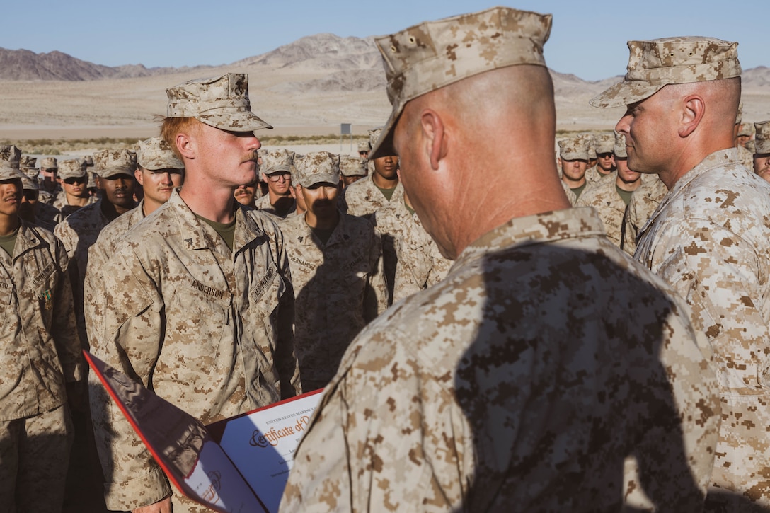 U.S. Marine Corps Lance Cpl. Jesse Anderson, a machine gunner with 1st Battalion, 6th Marine Regiment, 2d Marine Division, stands at attention while conducting his re-enlistment ceremony during Service Level Training Exercise 2-25, at Marine Corps Air-Ground Combat Center, Twentynine Palms, California, April 9, 2025. SLTE 2-25 is designed to enhance lethality and prepare units to fight in any climate and place. (U.S. Marine Corps photo by Lance Cpl. Hunter J. Kuester)
