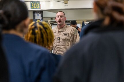 Lt. Cmdr. Corey Sommer, 1st lieutenant aboard the world’s largest aircraft carrier, USS Gerald R. Ford (CVN 78), speaks to Sailors assigned to deck department in the fo’c’sle, March 17, 2025.