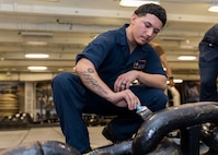 Boatswain’s Mate Seaman Jonathan Beltran, assigned to deck department aboard the world’s largest aircraft carrier, USS Gerald R. Ford (CVN 78), paints an anchor chain in the fo’c’sle, March 17, 2025.