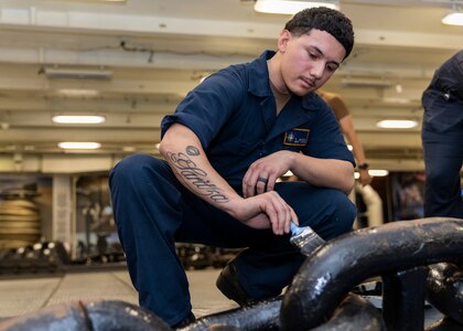 Boatswain’s Mate Seaman Jonathan Beltran, assigned to deck department aboard the world’s largest aircraft carrier, USS Gerald R. Ford (CVN 78), paints an anchor chain in the fo’c’sle, March 17, 2025.