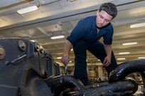 Boatswain’s Mate Seaman Jonathan Beltran, assigned to deck department aboard the world’s largest aircraft carrier USS Gerald R. Ford (CVN 78), paints an anchor chain in the fo’c’sle, March 17, 2025.