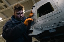 Aviation Structural Mechanic 3rd Class Shea Fortin, assigned to the “Tridents” of Helicopter Sea Combat Squadron (HSC) 9, removes a pylon lock pin from an MH-60S Sea Hawk during routine maintenance in the hangar bay of the world's largest aircraft carrier, USS Gerald R. Ford (CVN 78), March 18, 2025.