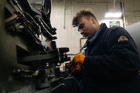 Aviation Structural Mechanic 3rd Class Shea Fortin, assigned to the “Tridents” of Helicopter Sea Combat Squadron (HSC) 9, inspects a washer from a pylon lock pin on an MH-60S Sea Hawk during routine maintenance in the hangar bay of the world's largest aircraft carrier, USS Gerald R. Ford (CVN 78), March 18, 2025.