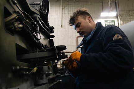 Aviation Structural Mechanic 3rd Class Shea Fortin, assigned to the “Tridents” of Helicopter Sea Combat Squadron (HSC) 9, inspects a washer from a pylon lock pin on an MH-60S Sea Hawk during routine maintenance in the hangar bay of the world's largest aircraft carrier, USS Gerald R. Ford (CVN 78), March 18, 2025.