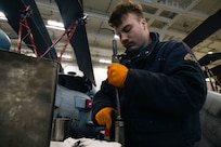 Aviation Structural Mechanic 3rd Class Shea Fortin, assigned to the “Tridents” of Helicopter Sea Combat Squadron (HSC) 9, disassembles the housing of a pylon lock pin on an MH-60S Sea Hawk during routine maintenance in the hangar bay of the world's largest aircraft carrier, USS Gerald R. Ford (CVN 78), March 18, 2025.