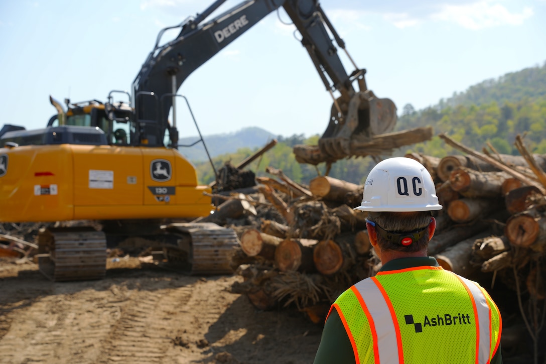 A quality control observer watches as an excavator sorts debris removed from the bottom of Lake Lure in Rutherford County, North Carolina, on April 14, 2025. The submerged debris is made up of vegetative and man-made debris washed into Lake Lure when Hurricane Helene impacted the area.