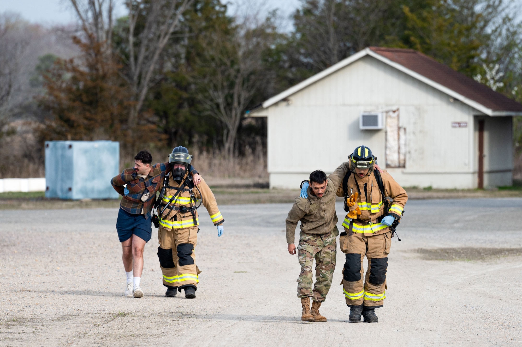Emergency responders carry patients during an exercise.