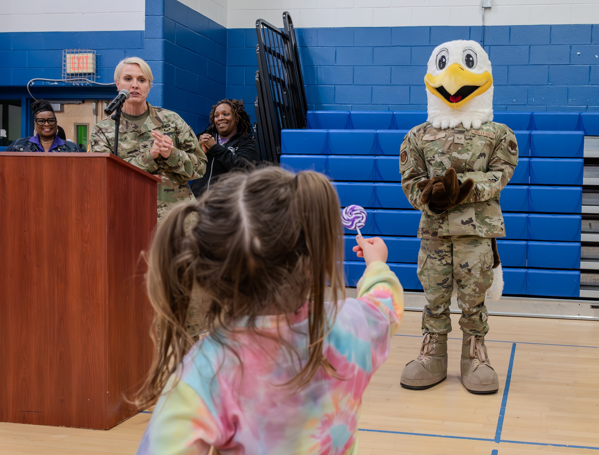A child offers JB the Eagle, Joint Base Langley-Eustis’ mascot, a lollipop