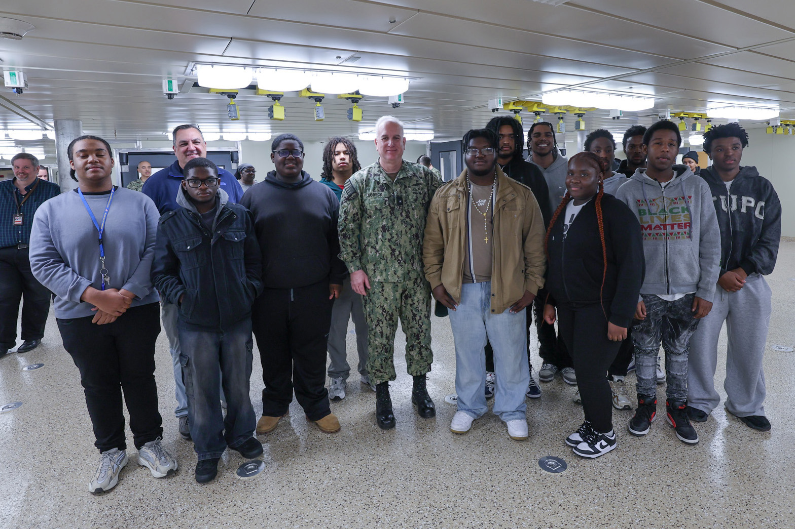 Military Sealift Command Commander, Rear Adm. Philip Sobeck, poses for a photo with seniors from Oscar Smith High School during a visit aboard the expeditionary fast transport vessel USNS Cody (T-EPF 14). Students from the Chesapeake, Virginia, high school visited the ship to learn about life as a civil service mariner.