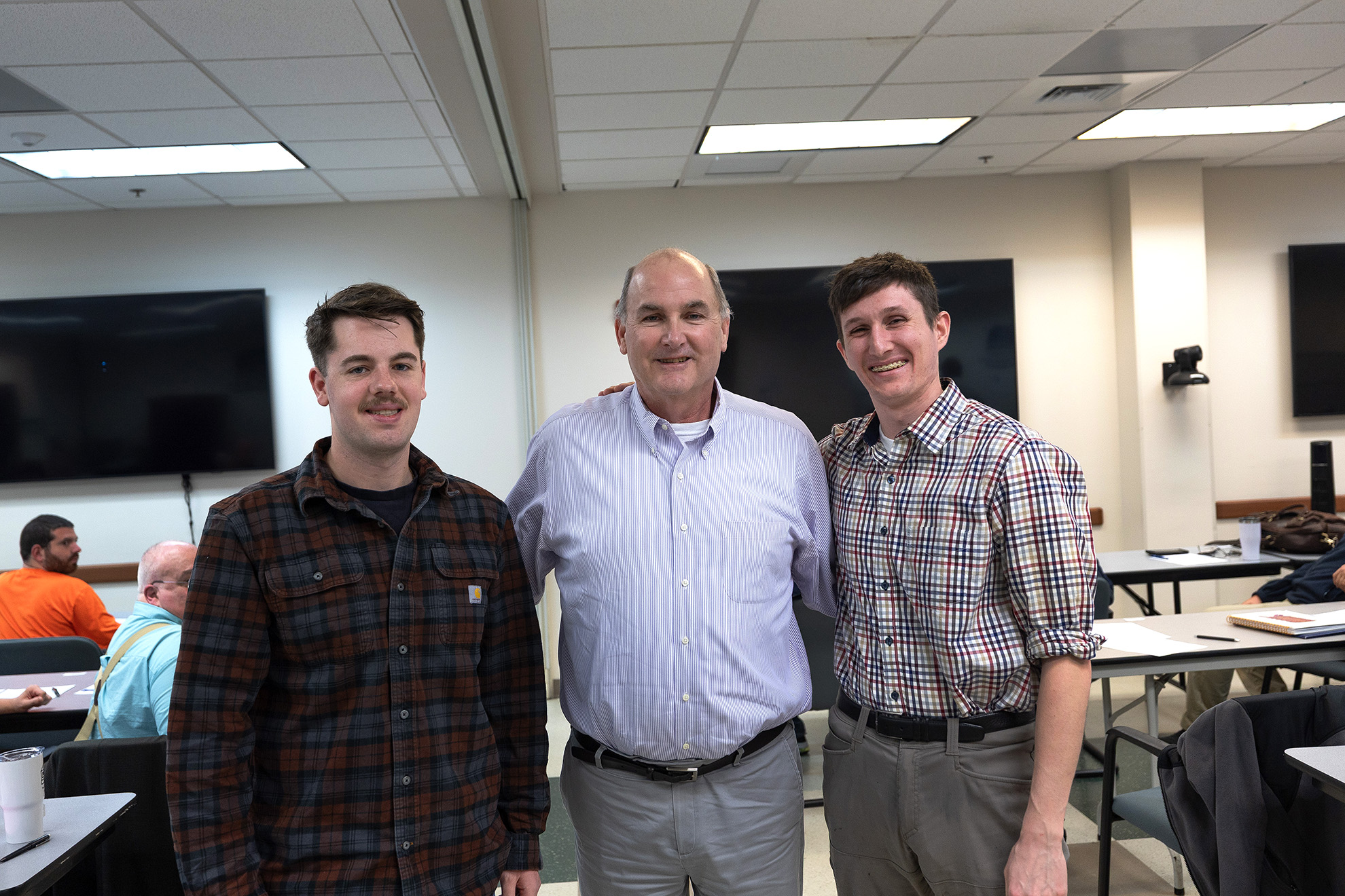 Civil Service Mariner Aiden Luetkmeyer (left), Military Sealift Command Deputy Total Force Management Frank Cunningham and Civil Service Mariner Ryan Welsh pose for a photo during a New Employment Orientation class at Naval Station Norfolk. Luetkmeyer and Welsh are the first Civil Service Mariner licensed officers hired under Military Sealift Command’s Expedited Onboarding Initiative.