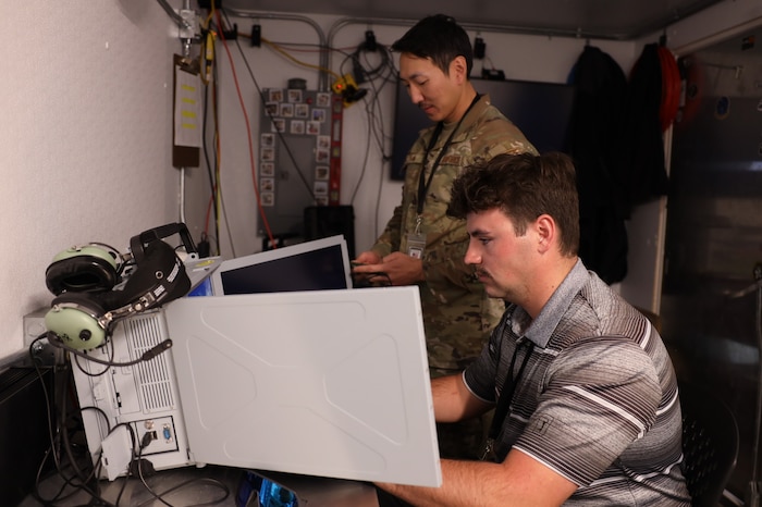 Tech. Sgt. Jay Han and Brendon Jones run a test of their data collection equipment from the Tactical Operations Center – Light during Project Convergence Capstone 5, at the National Training Center, Fort Irwin, California, March 10, 2025. Han, a data link systems tester, and Jones, a test engineer, with the 46th Test Squadron gather data to assess the TOC-L's performance in a simulated operational environment, ensuring its reliability and effectiveness in multi-domain operations. (Official Air Force Photo by Morgan Brown).