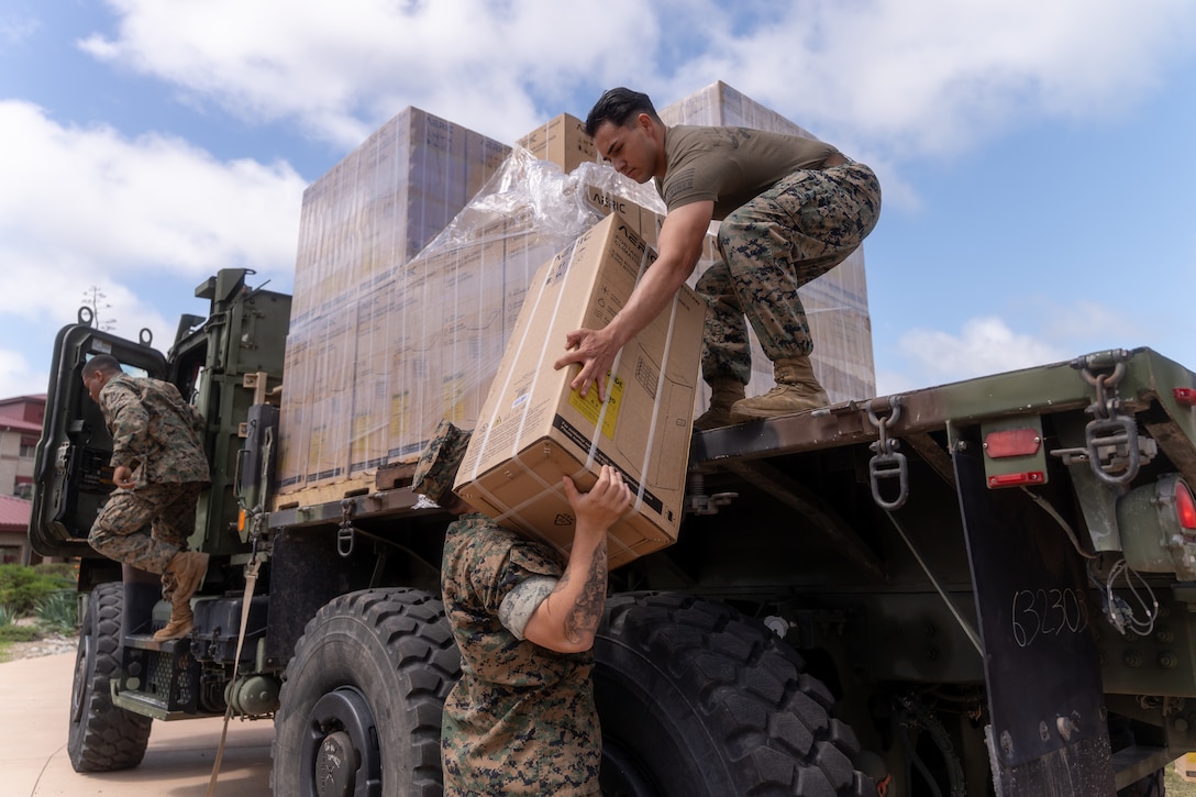 U.S. Marines with Headquarters Battalion, 1st Marine Division, unload air conditioning units during Operation Clean Sweep II at Marine Corps Base Camp Pendleton, California, March 28, 2025.