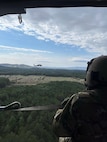 Soldiers from Knoxville’s 1-230th Assault Helicopter Battalion prepare to drop water from a Helicopter Bucket to combat a wildfire near Turtletown, in Polk County, April 15.