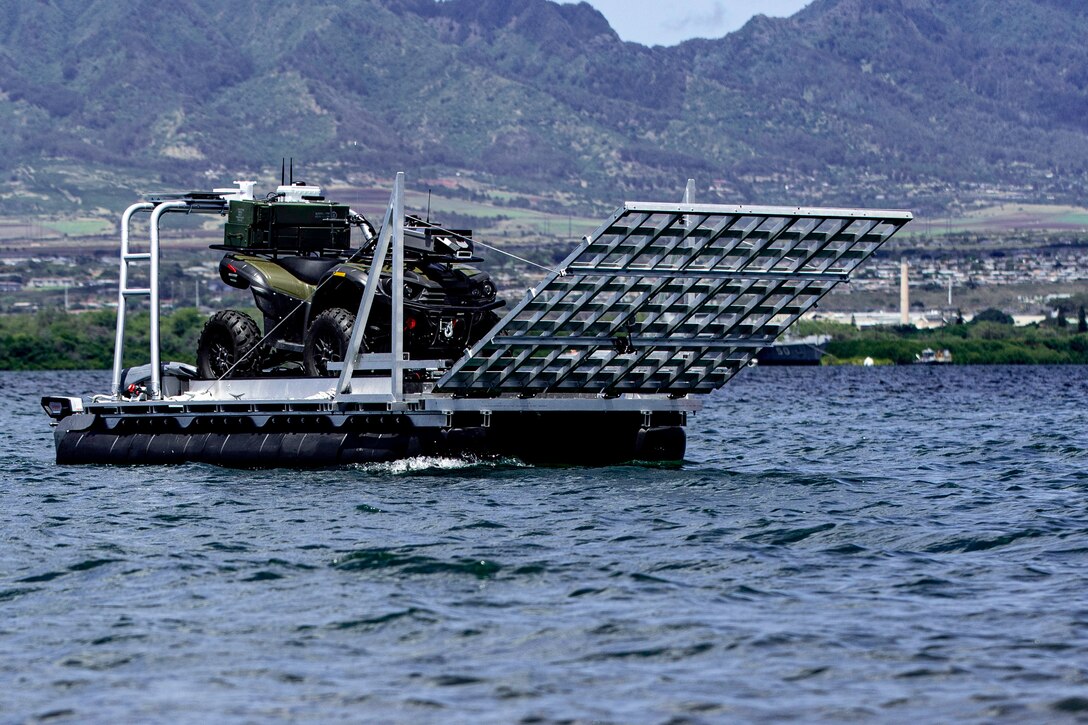 An autonomous floating platform carries a small four-wheel vehicle.