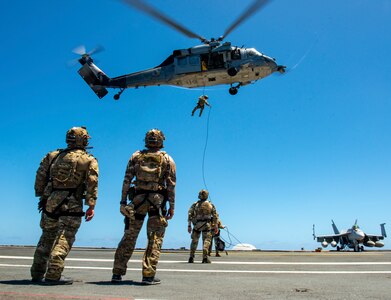 Members of Explosive Ordnance Disposal Mobile Unit 11 repel out of an MH-60S Sea Hawk helicopter from the “Indians” of Helicopter Sea Combat Squadron (HSC) 6 onto the flight deck of the aircraft carrier USS Nimitz (CVN 68) in the Pacific Ocean, April 13, 2025.
