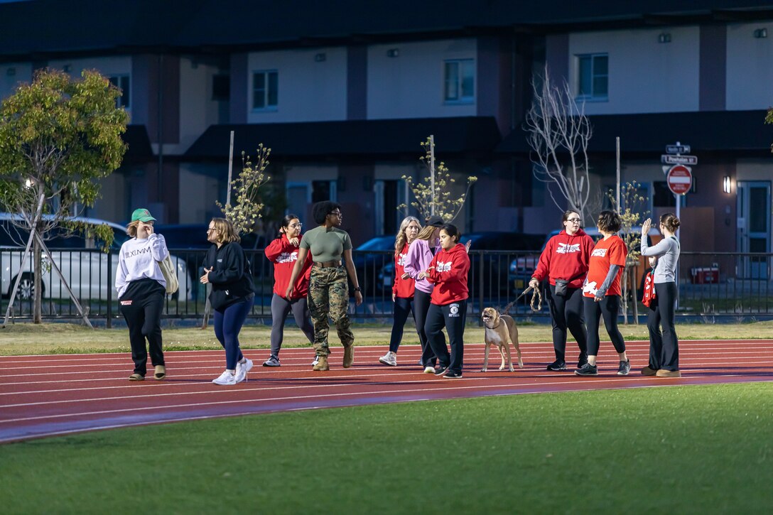 A U.S. Marine  and Marine Corps Air Station Iwakuni residents participate in the 2025 You Are Not Alone 24 Hour Walk at the North Side Track on MCAS Iwakuni, Japan, April 10, 2025. This event was held by Marine Aerial Refueler Transport (VMGR) 152, Marine Aircraft Group 12, 1st Marine Aircraft Wing, to bring awareness to Sexual Assault Awareness and Prevention month and show support to sexual assault survivors by inviting all MCAS Iwakuni personal to come together and participate in the 2025 You Are Not Alone 24 Hour Walk event. (U.S. Marine Corps photo by Cpl. Dahkareo Pritchett)