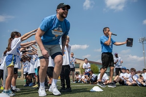 An NFL player is introduced during a football camp.