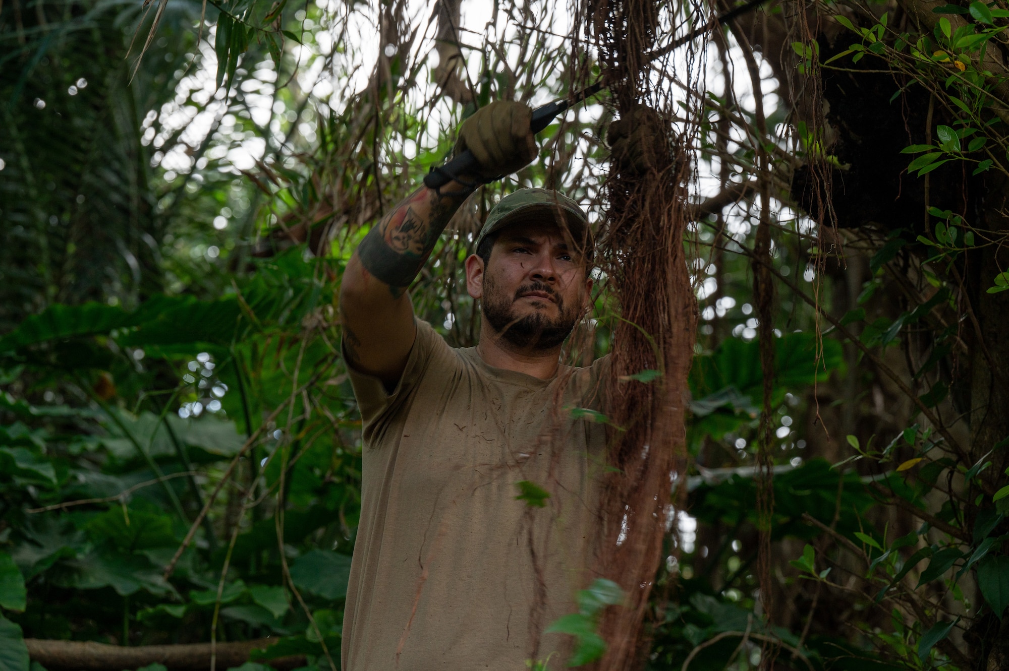 An airman cutting down vines