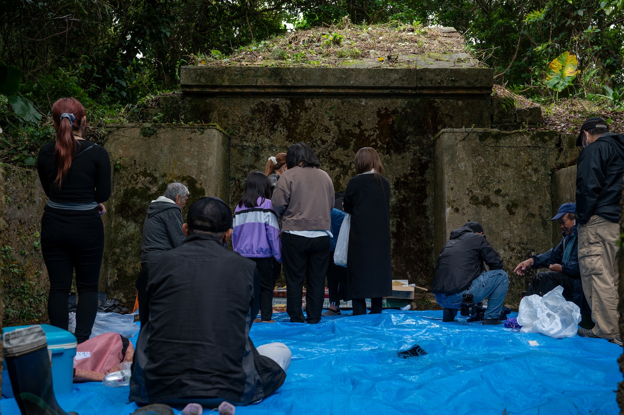 A family offering prayers at a tomb